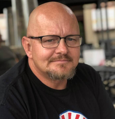 A bald man wearing glasses.