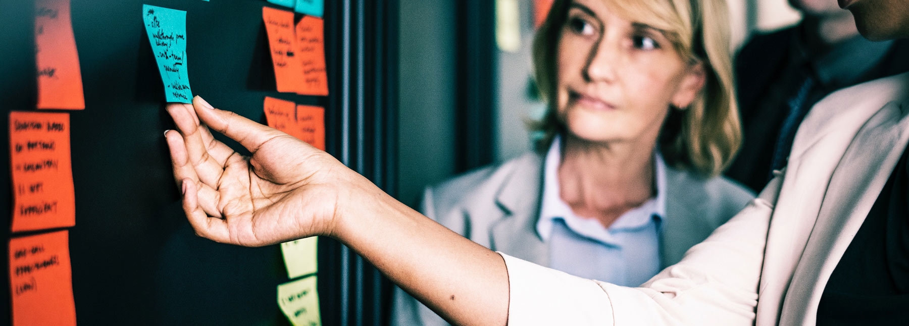 women working looking at post-it notes
