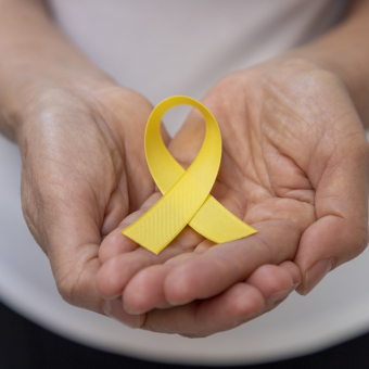 Suicide Prevention - hands holding yellow ribbon