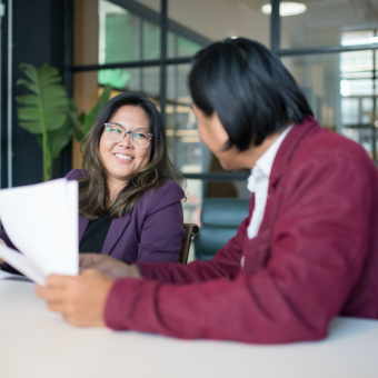 Woman smiling and talking to Man in Conference Room