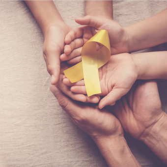 Suicide prevention image of hands holding yellow ribbon