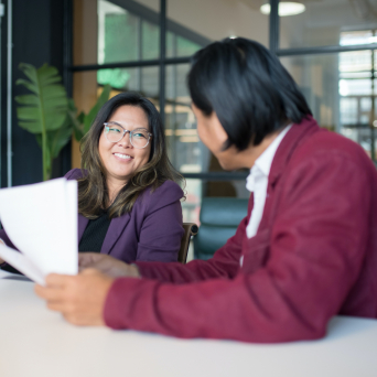 Woman smiling and talking to Man in Conference Room