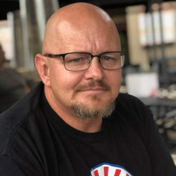 A bald man wearing glasses.