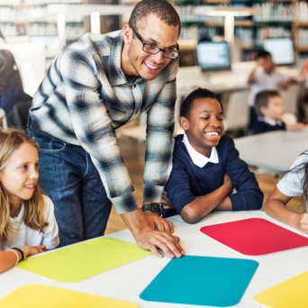 Teacher and students interacting in school library