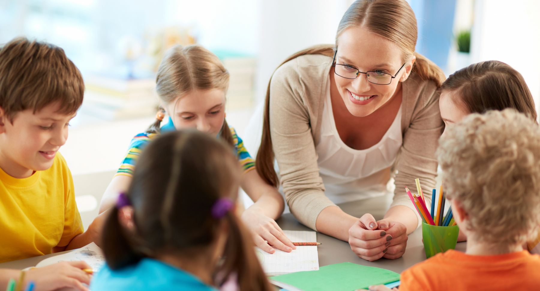 Happy teacher talking to her students 
